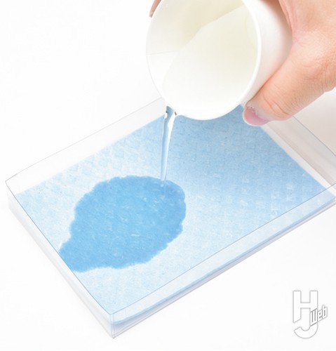 スポンジに紙コップで水を含ませている画像