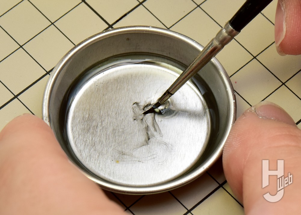 塗料皿の中で筆の洗浄をうすめ液でおこなっている画像