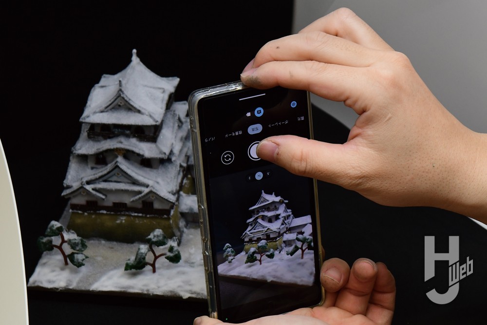 撮影ブース内で完成した彦根城をスマホで撮影している画像