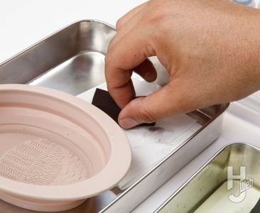 水を含ませたスポンジをペーパータオルで水分調整している
