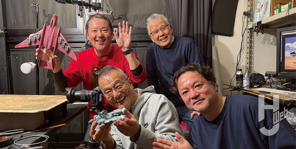 撮影ブースで記念撮影する連載陣とカメラマンの本松昭茂氏