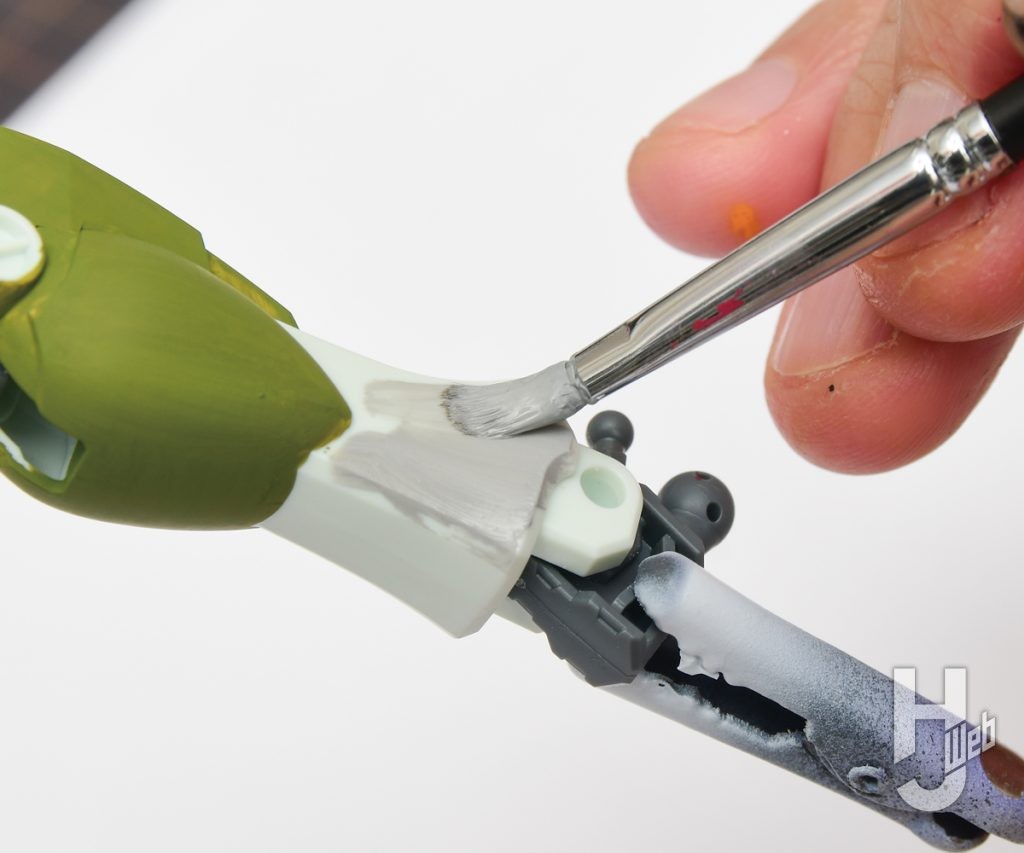 混色したアクリルガッシュをプラモデルに塗装している画像