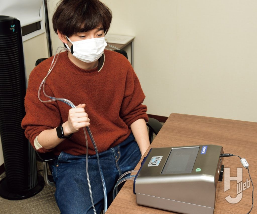 一般的な不織布マスクを着用して計測器で計測している画像