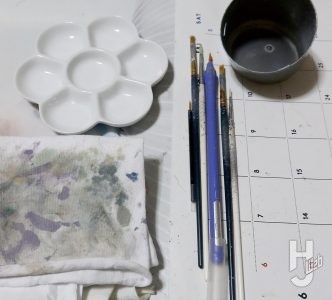 筆と梅パレットと雑巾と水の入ったコップ